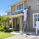 Two painters repainting the exterior of a double-storey South African home