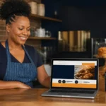South African small business owner reviewing her new website on a laptop in her bakery